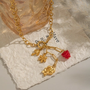Detail of 18K gold-plated chunky chain necklace with mushroom and raspberry pendants