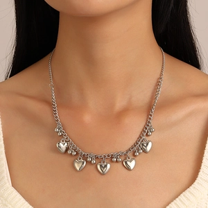 Silver metal necklace with heart pendants and metal beads on a cross chain for women