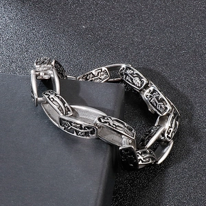 Vintage punk stainless steel chain bracelet with intricate floral carvings on dark base