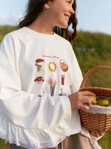Loose cream sweatshirt with lace trim hem and Summer Village print outdoors