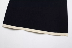 Primer plano de la textura de punto negro y borde en contraste crema en el dobladillo