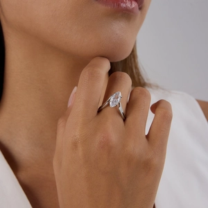 Detail of marquise-cut gemstone ring in silver finish worn by a model for elegant look