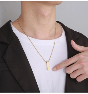 Close-up of a minimalist gold vertical bar pendant necklace worn on a model's neck