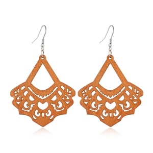 Detailed view of hollow geometric wood earrings with ethnic pattern and silver hooks