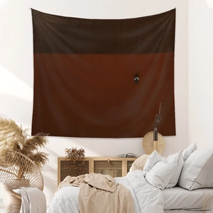 Minimalist bohemian tapestry with abstract silhouette on a wall in a warm bedroom setting