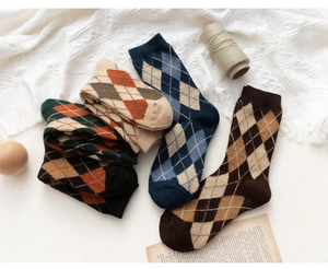 Close-up of vintage argyle wool socks in various colors on a warm knit background