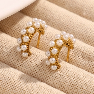 Close-up of vintage C-shaped 18K gold plated earrings with white pearl floral clusters