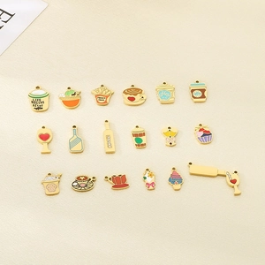 Flat lay of diverse coffee and drink charms with colorful enamel finish on beige linen