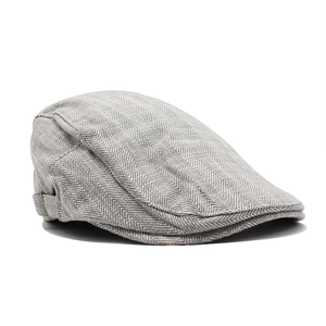 Detail of grey herringbone flat cap showing side buckle and textured wool fabric