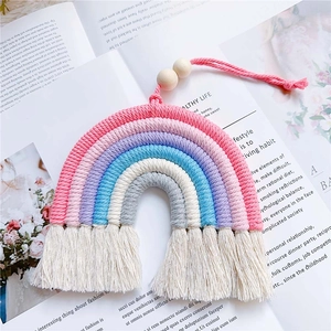 Detail of handmade rainbow wall hanging with colorful cotton ropes and wooden beads decor