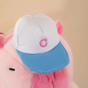 Close-up of pink Capybara plush backpack with a blue and white embroidered C-letter hat