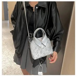 Silver shirt-shaped tote bag with marble texture shown on a stylish model's shoulder