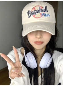 Detail of cream baseball cap with colorful Baseball Mom embroidery worn by a model