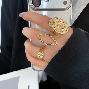 Detail of gold textured irregular ring set on hand with molten metal finish aesthetic