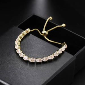 Close-up of luxury gold-tone adjustable slider bracelet with oval-cut zircon stones