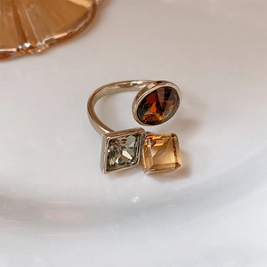 Macro detail of gold plated ring featuring brown and amber geometric cubic zirconia
