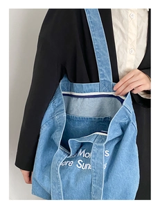 Détail montrant l'intérieur grande capacité et la poche plaquée du cabas en denim bleu