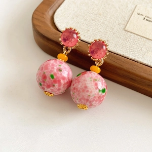 Gros plan de boucles d'oreilles vintage en céramique avec perles roses et dorées