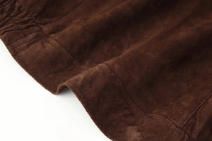 Detailaufnahme der hochwertigen schokobraunen Wildlederjacke mit feinen Doppelsteppnähten