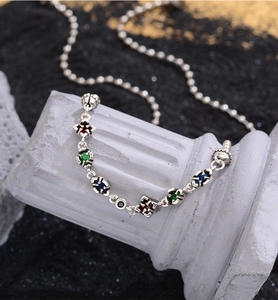 Macro shot of silver hip-hop chain with colorful zircon beads on a classical stone pillar
