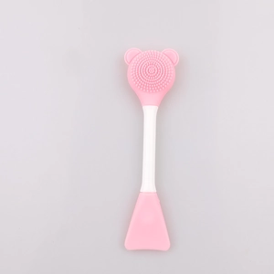 Detail of pink silicone bear-shaped face cleanser brush and facial mask spatula tool