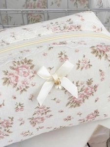 Detail der floralen Kosmetiktasche mit Spitze, Satinschleife und Perlenanhänger