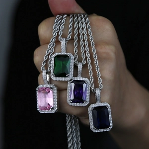 Macro shot of silver hip hop necklaces with square pendants in green, pink, purple, and blue