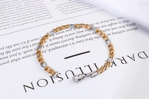 Detail of two-tone gold and silver stainless steel Cuban chain bracelet with lobster clasp