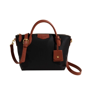 Lightweight black nylon tote bag with brown leather handles and a gold-tone zipper