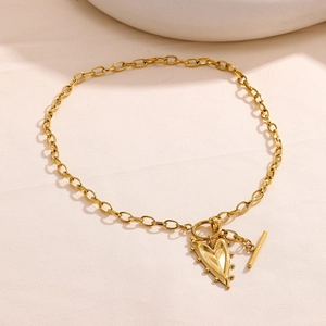 Dettaglio della collana con ciondolo a cuore dorato, chiusura a T e catena a maglie spesse