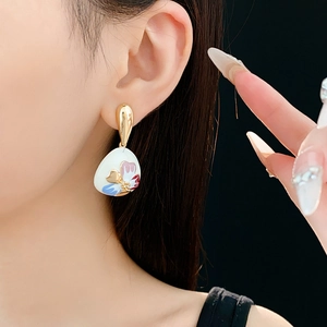 Close-up of vintage flower earrings with white and blue floral patterns on model