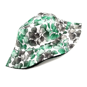Detail of floral bucket hat with green leaf print and reinforced stitching on the brim