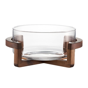 Transparent glass salad bowl with minimalist dark brown wood stand on white background