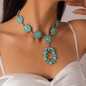 Close-up of vintage gold necklace with blue resin stones and diamond accents on neck