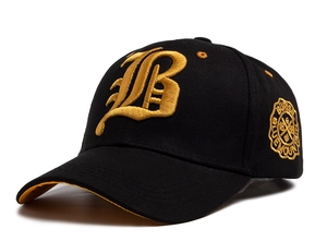 Close-up of golden 3D embroidered B and vintage side badge on black cotton baseball cap