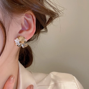 Close-up of vintage flower earrings with champagne crystals worn by a female model