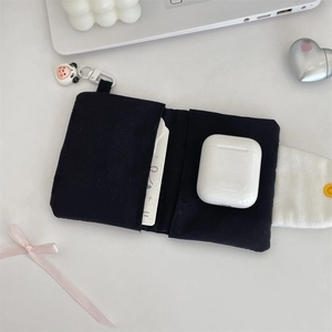 Détail du porte-cartes en tissu noir avec charmant pendentif panda et bouton pression.