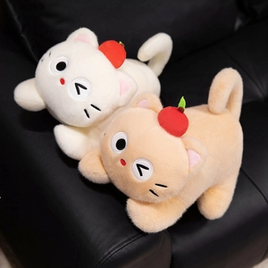 Cute plush cat doll with red apple hat in white and brown colors on black sofa