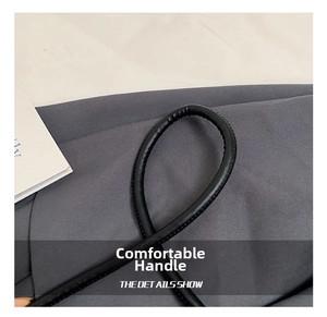 Close-up of the black leather handle with detailed stitching on the wool tote bag