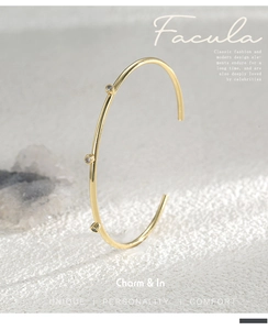 Detailed close-up of an adjustable gold-plated brass cuff bracelet with three inset zircons