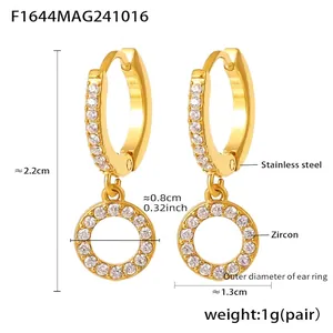 Macro detail of gold stainless steel hoop earrings featuring inlaid cubic zirconia accents