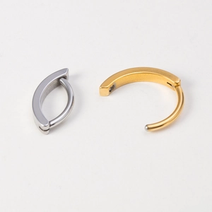 Close-up of gold and silver stainless steel belly rings in open and closed positions