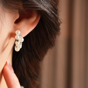 Primer plano de elegantes pendientes de perlas con brillantes pedrería en la oreja de modelo
