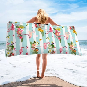 Detail showing oversized microfiber beach towel with flamingo and hibiscus tropical prints