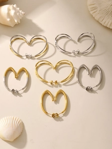 Vue à plat de boucles d'oreilles créoles cœur minimalistes en or et argent poli