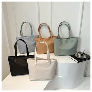 Minimalist nylon tote bags shown in five colors on a professional display stand