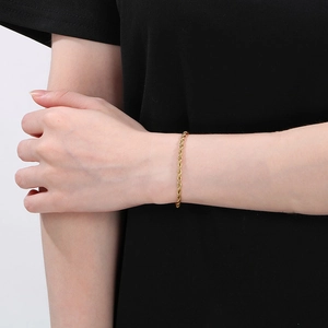 Detail of gold-plated stainless steel rope chain bracelet worn on a female wrist