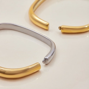 Vista macro dettagliata di bracciali quadrati minimalisti in oro e argento lucido fine