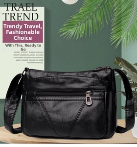 Détail d'un sac bandoulière noir en cuir grainé avec plusieurs poches zippées