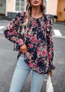 Detailed view of the elastic smocked neckline and floral print on a long sleeve blouse